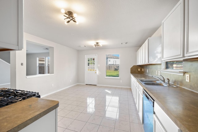 kitchen with white cabinetry, sink, stainless steel dishwasher, a textured ceiling, and light tile patterned flooring