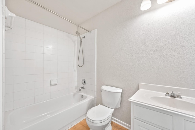 full bathroom featuring hardwood / wood-style floors, vanity, toilet, and tiled shower / bath combo