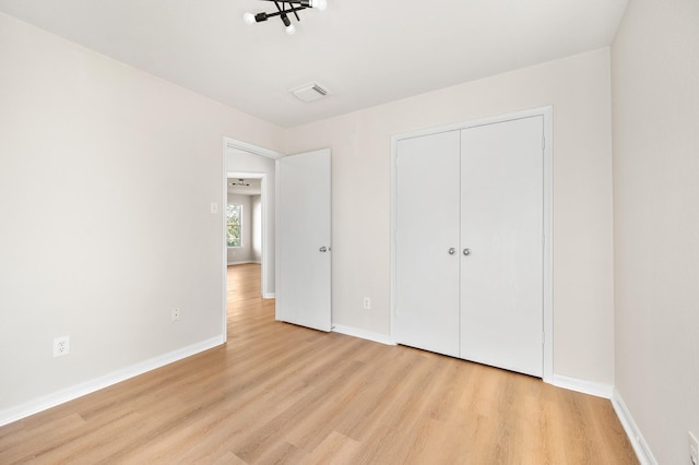 unfurnished bedroom featuring a closet and light wood-type flooring