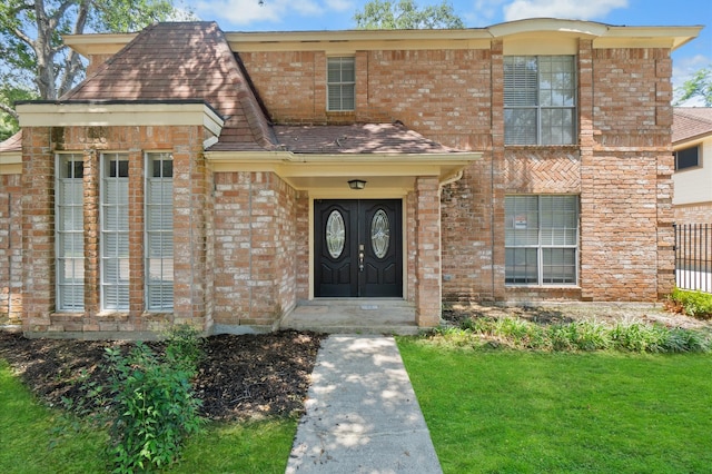 property entrance with a lawn