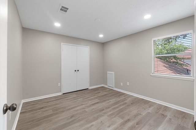 unfurnished bedroom featuring a closet and light hardwood / wood-style flooring