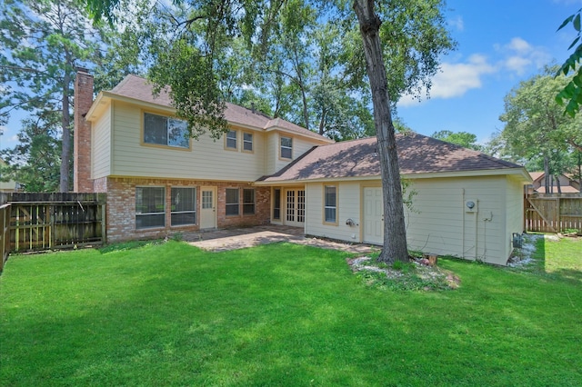 back of property with a patio area and a yard