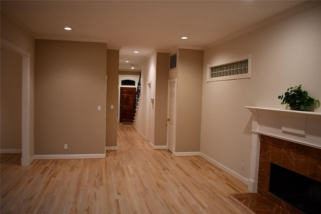 corridor with ornamental molding and light wood-type flooring