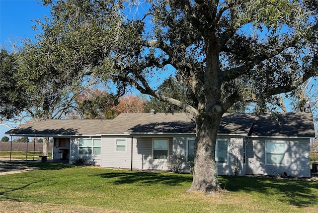 ranch-style home featuring a carport and a front yard