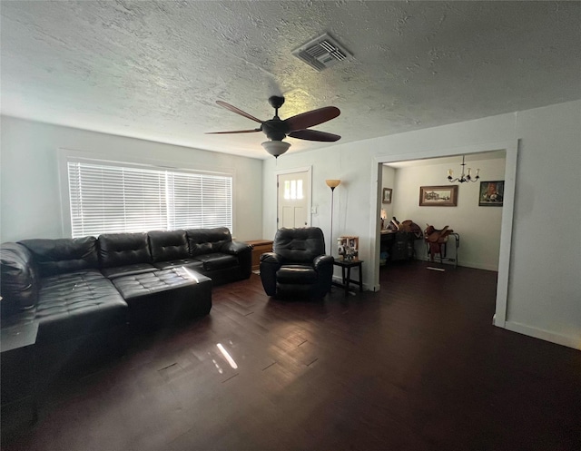 living room featuring dark hardwood / wood-style floors, a textured ceiling, and ceiling fan with notable chandelier