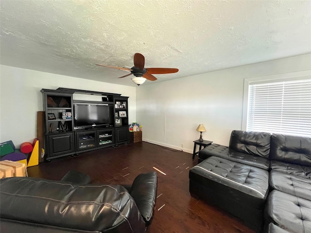 living room with a textured ceiling, dark hardwood / wood-style floors, and ceiling fan