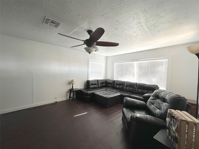 living room with ceiling fan, dark hardwood / wood-style flooring, and a textured ceiling