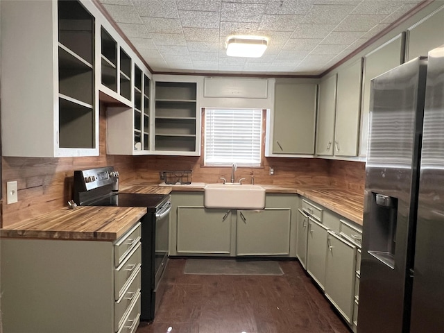 kitchen with butcher block countertops, green cabinets, sink, and appliances with stainless steel finishes