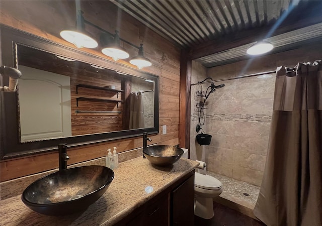 bathroom featuring wooden walls, toilet, vanity, and a shower with shower curtain