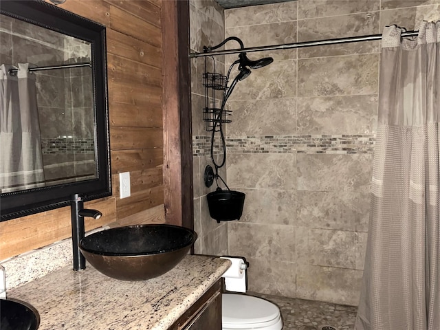 bathroom featuring vanity, toilet, walk in shower, and wooden walls