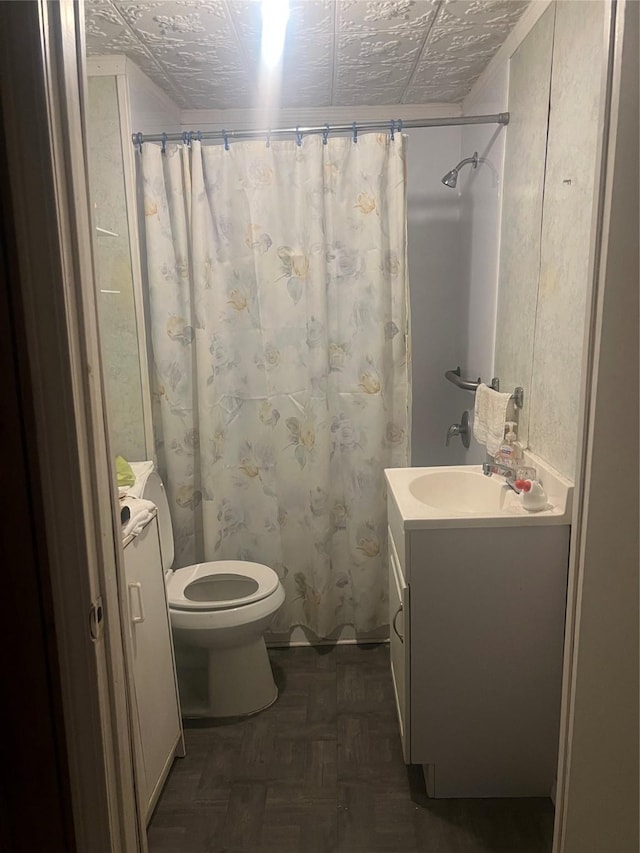 bathroom featuring parquet flooring, a textured ceiling, vanity, and toilet