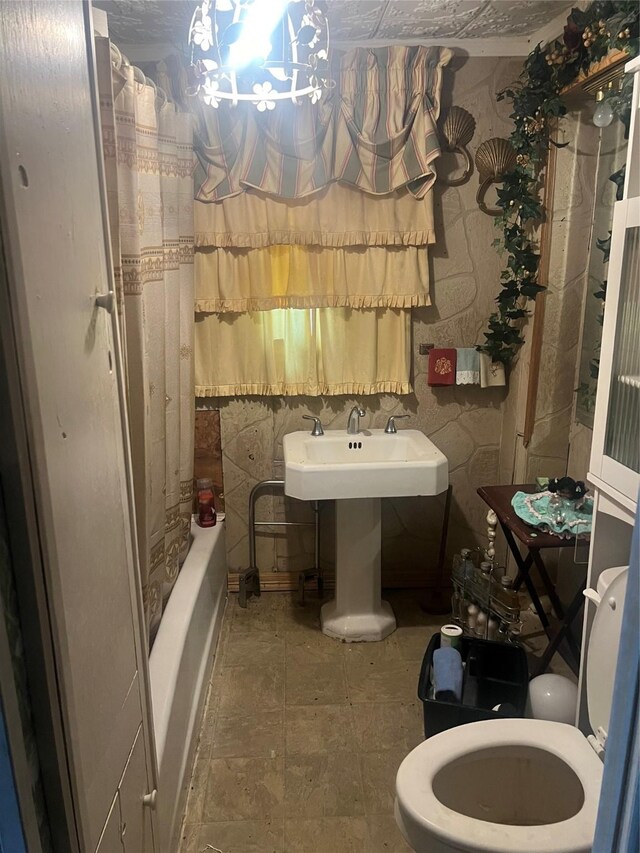 full bathroom featuring toilet, shower / bathtub combination with curtain, and sink