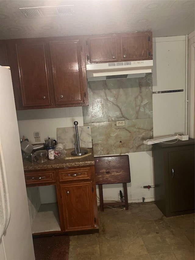 kitchen featuring backsplash and white fridge