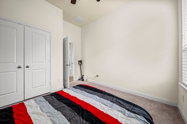 carpeted bedroom featuring ceiling fan, lofted ceiling, and a closet