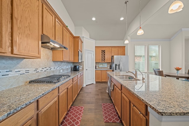 kitchen featuring sink, vaulted ceiling, hanging light fixtures, appliances with stainless steel finishes, and a kitchen island with sink