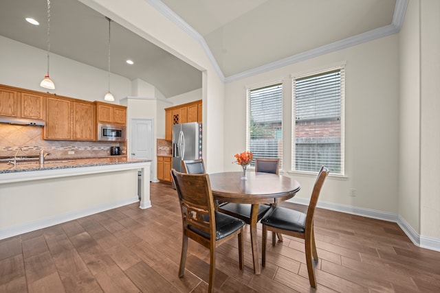 dining area with ornamental molding, lofted ceiling, and dark hardwood / wood-style floors