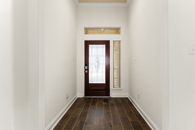 foyer with dark wood finished floors, baseboards, and ornamental molding