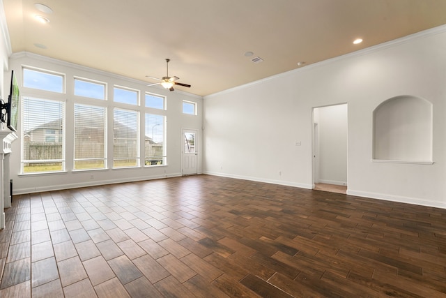 spare room with a ceiling fan, baseboards, visible vents, dark wood-style flooring, and ornamental molding