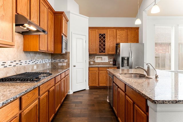 kitchen featuring a sink, stainless steel appliances, brown cabinets, and wall chimney exhaust hood