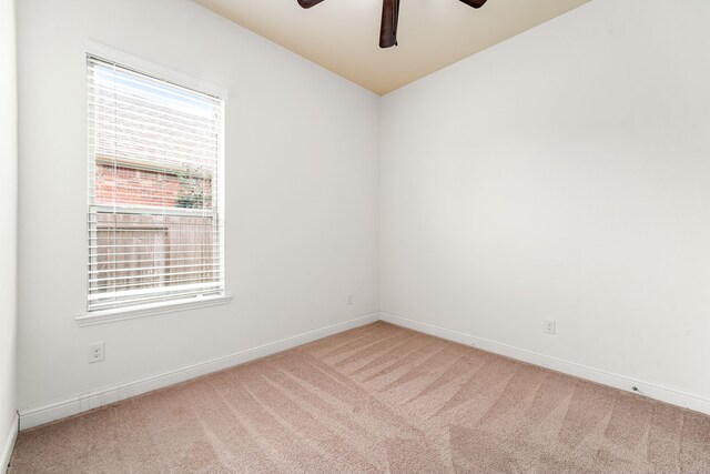 carpeted spare room with baseboards and ceiling fan