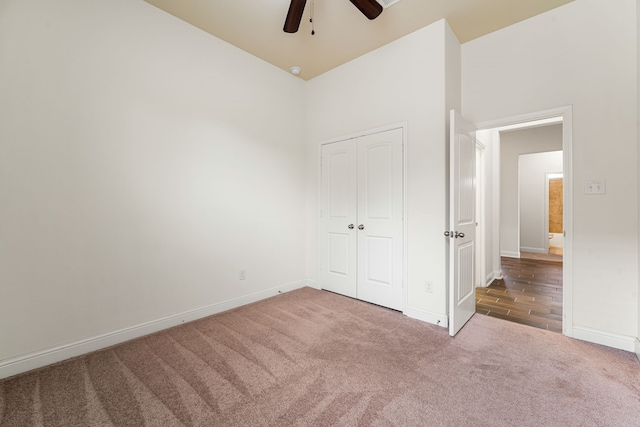 unfurnished bedroom with a closet, ceiling fan, baseboards, and carpet floors