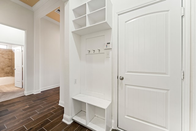 mudroom with wood finish floors, visible vents, baseboards, and ornamental molding