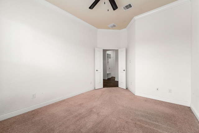 carpeted empty room with visible vents, baseboards, ornamental molding, and a ceiling fan