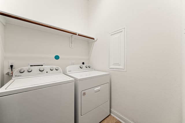 washroom featuring laundry area, baseboards, and washer and clothes dryer