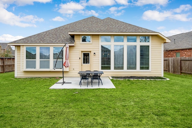 rear view of property with a patio area, a fenced backyard, a lawn, and roof with shingles