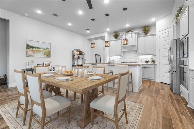 dining space with wood finished floors, visible vents, and recessed lighting