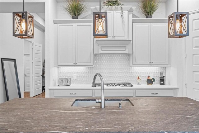 kitchen featuring premium range hood, decorative light fixtures, and decorative backsplash