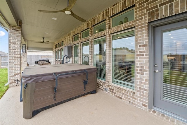 view of patio with ceiling fan and a hot tub