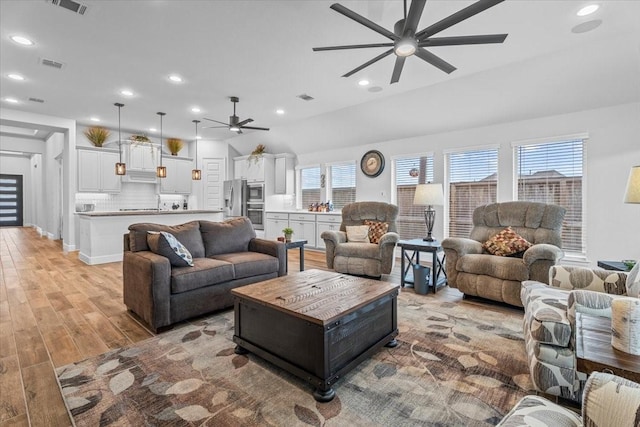 living area featuring a ceiling fan, light wood-type flooring, visible vents, and recessed lighting