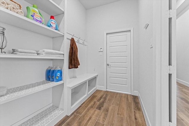 mudroom with dark wood-style floors and baseboards