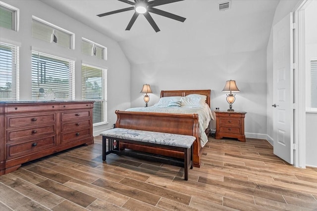 bedroom with lofted ceiling, baseboards, visible vents, and wood finish floors