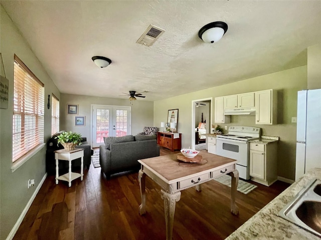 kitchen featuring white appliances, french doors, white cabinets, ceiling fan, and dark hardwood / wood-style floors