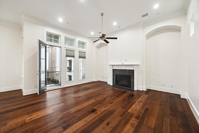 unfurnished living room with a fireplace, ornamental molding, ceiling fan, and dark wood-type flooring