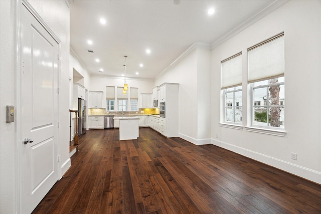 kitchen with a healthy amount of sunlight, dark wood-type flooring, a kitchen island, and pendant lighting