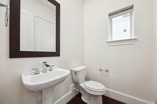 bathroom with toilet and wood-type flooring