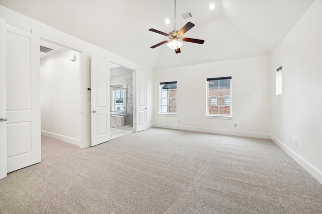 carpeted empty room with ceiling fan and high vaulted ceiling