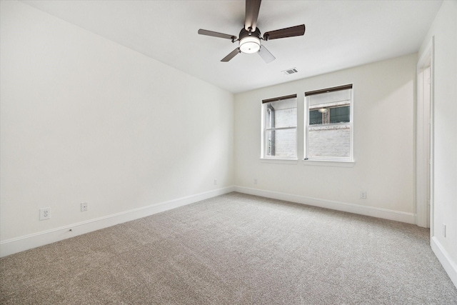 carpeted spare room featuring ceiling fan