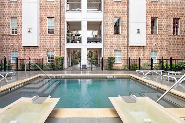 view of pool with a hot tub