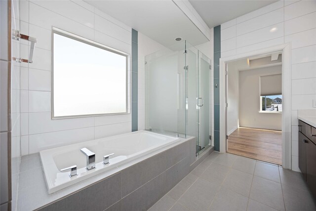 bathroom featuring shower with separate bathtub, vanity, and tile patterned floors