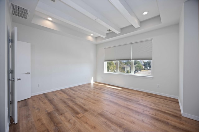 unfurnished room featuring hardwood / wood-style floors and beam ceiling