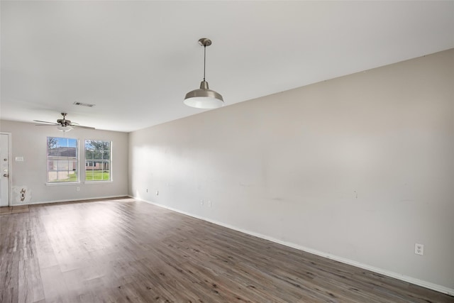 empty room with ceiling fan and dark wood-type flooring