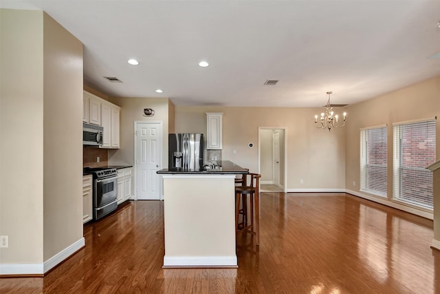 kitchen featuring decorative backsplash, appliances with stainless steel finishes, a center island, and pendant lighting