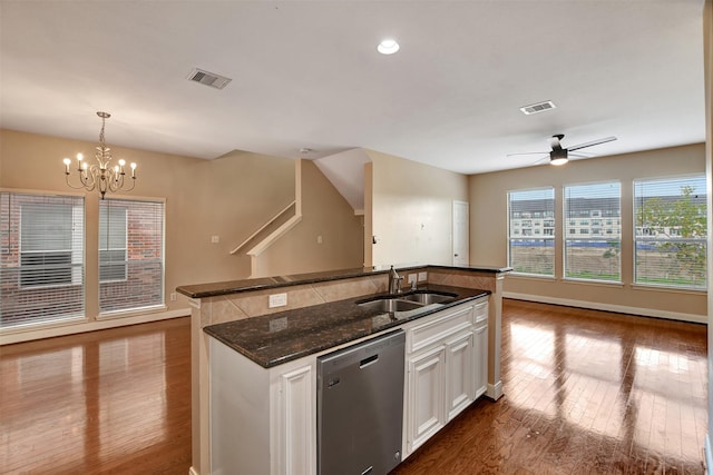 kitchen with dishwasher, sink, pendant lighting, white cabinets, and ceiling fan with notable chandelier