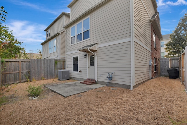 rear view of property featuring central AC unit and a patio area