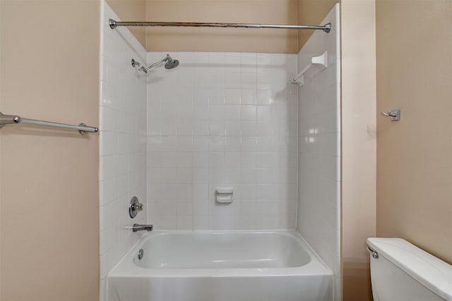 bathroom with toilet and tiled shower / bath