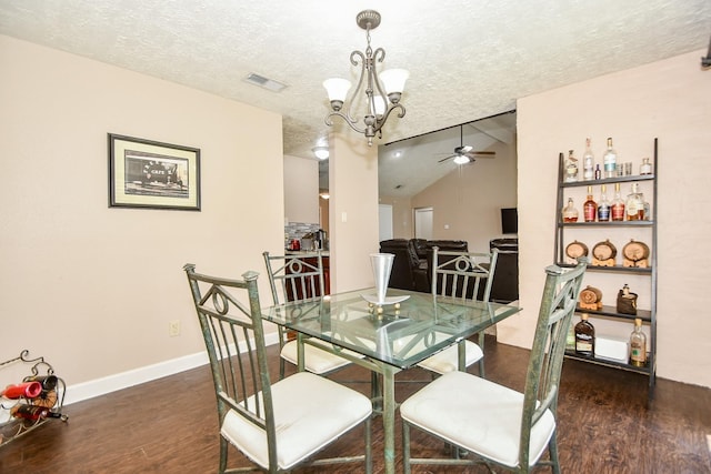 dining area featuring ceiling fan with notable chandelier, a textured ceiling, dark hardwood / wood-style flooring, and vaulted ceiling